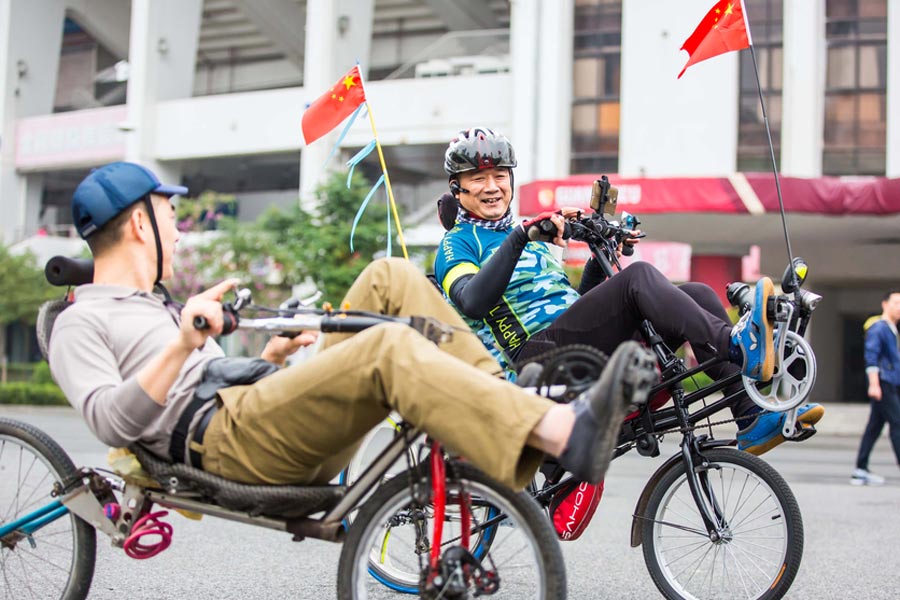 Cyclists sit back as they pedal through Guangzhou
