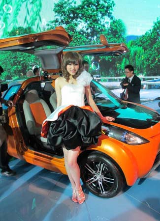 Model poses near Geely hybrid car