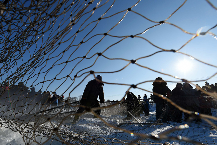 Winter fishing in ice-covered Changling Lake in Harbin