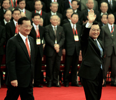 Hu Jintao, general secretary of the Communist Party of China Central Committee, Lien Chan (left), former chairman of Taiwan's opposition Kuomintang, and other delegates to the Cross-Straits Economic and Trade Forum applaud after a group photo at the Great Hall of the People in Beijing yesterday. Hu called for talks between the mainland and Taiwan as soon as possible to maintain cross-Straits peace. 