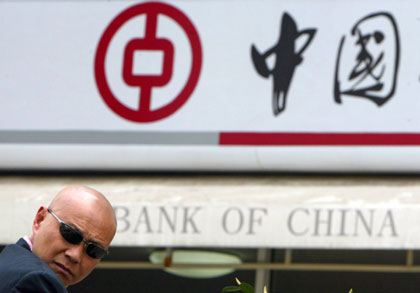 A man rests in front of a branch of Bank of China in China's financial center Shanghai April 18, 2006. Bank of China, the country's second-largest bank, 