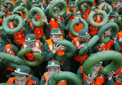 Chinese soldiers blow up life buoys during a drill in preparation for the coming of killer typhoon Chanchu in east China's Zhejiang Province, May 17, 2006. Typhoon Chanchu continues to move northward along the coastal areas of east China's Fujian Province after it landed in Guangdong. [Xinhua]