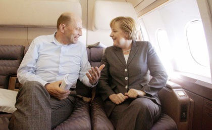 German Chancellor Angela Merkel (R) listens to German Transport and Construction Minister Wolfgang Tiefensee during their flight from Berlin to China's capital Beijing May 21, 2006. Merkel is on an official two-day visit to China. 