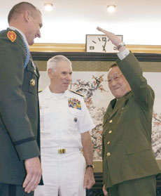 Chinese Defence Minister General Cao Gangchuan (R) measures an unidentified U.S. military officer as the commander of U.S. Pacific Command Admiral William Fallon (C) looks on during a meeting in the Chinese Ministry of Defence in Beijing May 10, 2006.