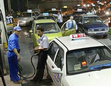 Taxis wait to get their tanks filled before the rise of the oil price at a gas station in Shanghai May 23, 2006.