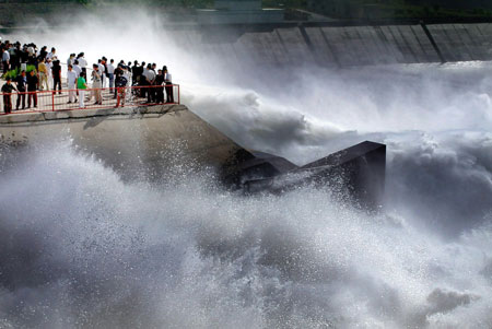 Tourists watch water flush out of the sluice of the Xiaolangdi Dam on the Yellow River in Central China's Henan Province June 18, 2006. The view attracts more than 10,000 visitors from across the country. [Xinhua]