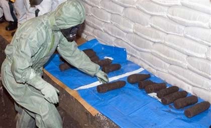 Chinese and Japanese chemical weapons experts in protective clothing dig up abandoned poison gas bombs in a pit in Ning'an, northeastern China's Heilongjiang province, Wednesday, July 5, 2006. The joint Chinese-Japanese team was preparing Wednesday to excavate abandoned Japanese poison gas bombs from World War II that were buried near a school after a factory received them as scrap metal. (AP Photo