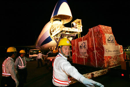 Airport workers load up a cargo plane from China Airlines, Taiwan's largest air carrier, at Taiwan international airport in Taipei July 19, 2006. Taiwan's first non-stop cargo charter flight to Chinese mainland will take off for Shanghai on Wednesday, taking full direct transport links a step closer between two economies across the Straits. [Reuters] 