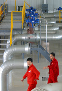 Workers walk by oil pipelines at PetroChina Dushanzi Petrochemical Company, in Dushanzi, China's northwestern Xinjiang Uygur Autonomous Region, July 29, 2006.