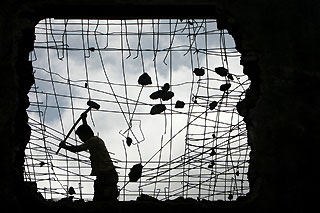 A labourer works at a demolished housing area in Haikou, southern China's Hainan province, September 25, 2006. 