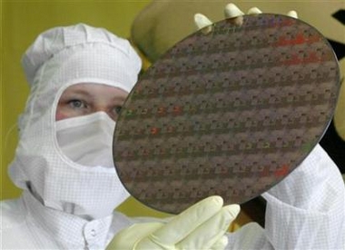A technician from Advanced Micro Devices is shown displaying a wafer to the media in the German city of Dresden, in this May 17, 2004 file photo. AMD, the world's number two maker of microchips for personal computers, has sealed a deal to supply China's second-largest PC maker with chips, scoring its latest victory in a market share battle with bigger rival Intel. (Arnd Wiegmann/Reuters