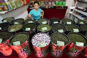 A shop vendor waits for customers at her tea counter in Shanghai October 12, 2006. 