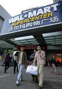Customers with shopping bags walk out of a Wal-Mart Supercenter in Beijing October 17, 2006. Wal-Mart Stores Inc. is teaming up with Chinese bank Shenzhen Development Bank to launch a credit card in China, tapping the country's $2 trillion in domestic savings
