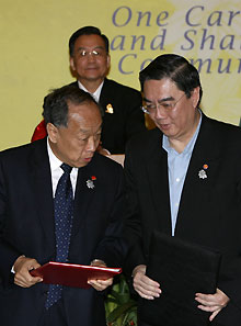 Foreign Minister Li Zhaoxing (L) talks to ASEAN secretariat Ong Keng Yong (R) in front of China's Prime Minster Wen Jiabao (C) after a signing ceremony for Trade in Service Agreement of the ASEAN-China Free Trade Area during the 12th Association of Southeast Asian Nations (ASEAN) summit in Cebu, central Philippines, January 14, 2007. 