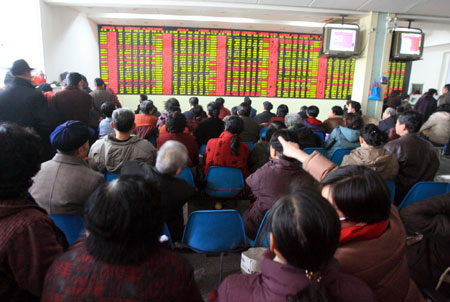 Stockholders monitor an electric board at a stock brokerage in Jinan, east China's Shandong province, January 25, 2007. The share prices on the Shenzhen and Shanghai stock markets dropped significantly on January 25.[newsphoto]
