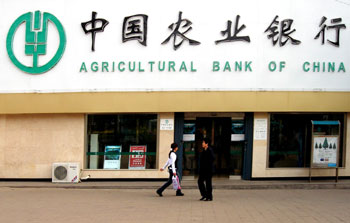 Pedestrians walk past a branch of Agricultural Bank of China in Shanghai. The Agricultural Bank of China is expected to get a huge capital injection from the government in the first half of the year, a substantial breakthrough in lender reform, a report said Wednesday. [newsphoto/file]