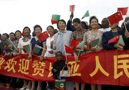 Members of Zambia's Chinese community wait to greet China's President Hu Jintao at Lusaka International Aiport, February 3, 2007. 