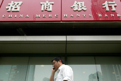 A man walks past China's Merchants Bank in Shanghai April 27 2006. China's Merchants Bank Co. Ltd. posted a 25-percent rise in first quarter earnings on Wednesday as the top Shanghai-listed lender notched up strong loan and deposit growth. 