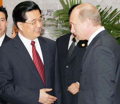 Russian President Vladimir Putin (R) and Chinese President Hu Jintao speak after a meeting at the Shanghai Cooperation Organization (SCO) summit in Shanghai June 15, 2006.