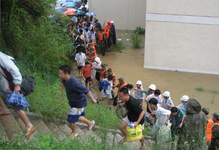 Chinese university students are evacuated from a flooded campus in Fuzhou, East China's Fujian Province, August 19, 2007. Some 2,500 students were transferred to safe areas after their campus was submerged and the electricity was cut off for one day due to the typhoon Sepat. [Xinhua]