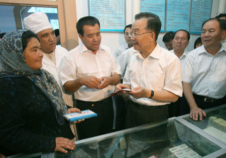 Chinese Premier Wen Jiabao (2nd R) talks with local people at a hospital during his inspection tour to the northwestern Xinjiang Uygur Autonomous Region from last Thursday to Sunday. Wen Jiabao visited villages, schools, enterprises, hospitals and the Xinjiang production and construction corps of the army in a number of prefectures and cities to show his extensive care for local people's livelihood, education, medical service and the development of energy sources，Xinhua reported.[Xinhua]