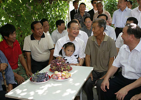 Chinese Premier Wen Jiabao (C) talks with local people at a villager's home during his inspection tour to the northwestern Xinjiang Uygur Autonomous Region from last Thursday to Sunday. Wen Jiabao visited villages, schools, enterprises, hospitals and the Xinjiang production and construction corps of the army in a number of prefectures and cities to show his extensive care for local people's livelihood, education, medical service and the development of energy sources，Xinhua reported.[Xinhua]