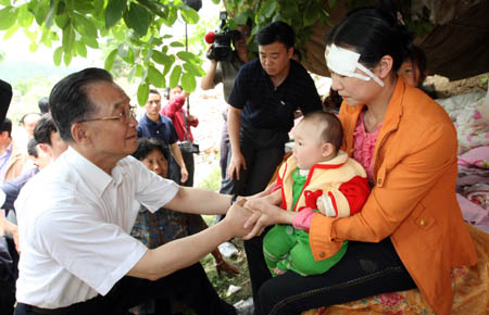Chinese Premier Wen Jiabao (L) comforts local people in Muyu Township, Qingchuan County, southwest China's Sichuan Province May 15, 2008. Qingchuan County is one of the worst-hit areas in Sichuan Province. Premier Wen is here to oversee rescue work and visit survivors. (Xinhua/Yao Dawei)