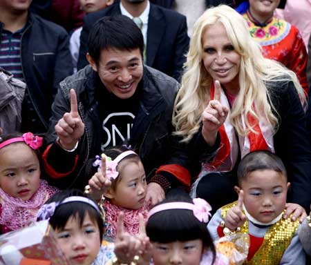Italian designer Donatella Versace (back, R) and Chinese actor Jet Li pose for photo with quake-affected children at the Versace-One Foundation children center at Sanjiang, Wenchuan county, southwest China&apos;s Sichuan Province, Nov. 11, 2008. 