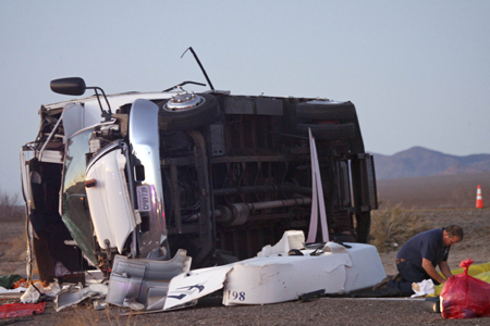 An official works at the scene of a fatal tour bus accident that left seven Chinese tourists dead on US-93 near Dolan Springs, Arizona Jan. 30, 2009. The bus packed with Chinese tourists rolled on a highway near the Hoover Dam on Friday killing seven passengers and injuring 9, an Arizona Department of Public Safety spokesman said.