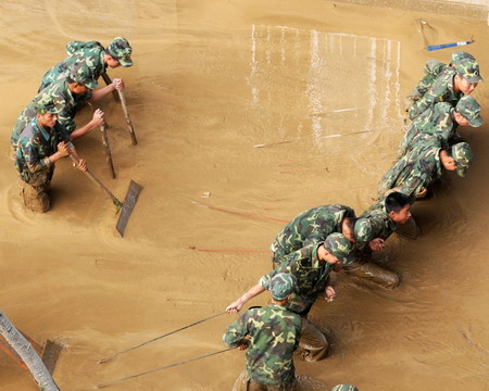 Locals and soldiers clean up after floods