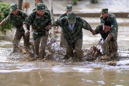 Locals and soldiers clean up after floods