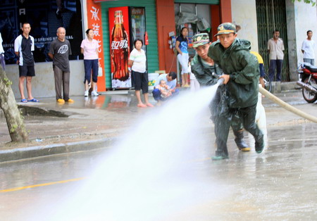 Locals and soldiers clean up after floods