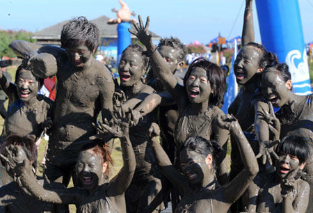Tourists play with sea mud in E. China