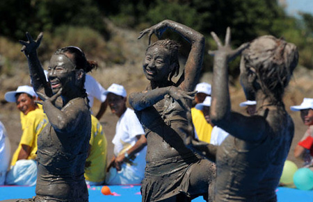 Tourists play with sea mud in E. China