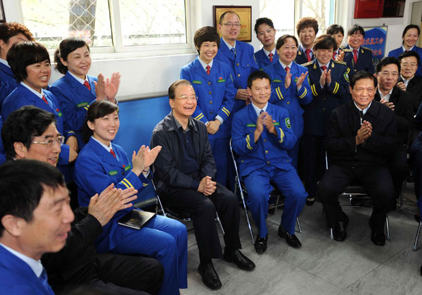 Premier Wen visits cleaners, bus drivers