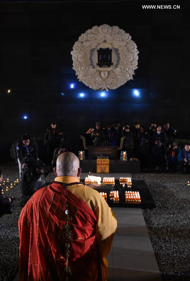 People hold candles to mourn victims of Nanjing Massacre