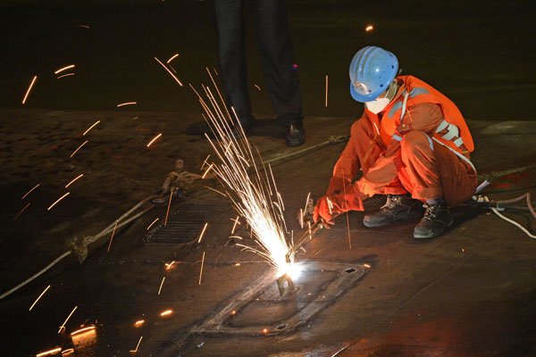 Rescue workers cut open ship's hull