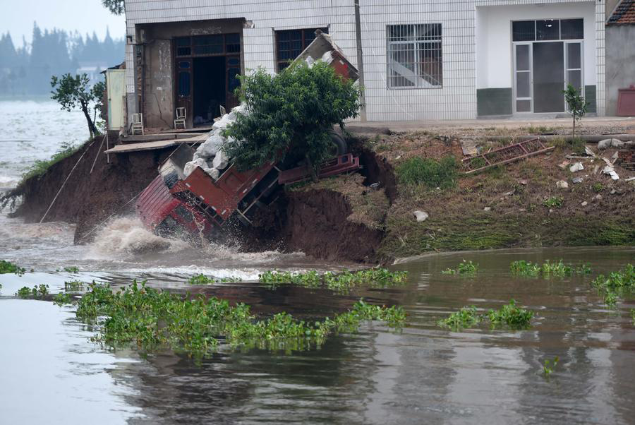 Rescuers risk life, drive heavy trucks to block floodwater