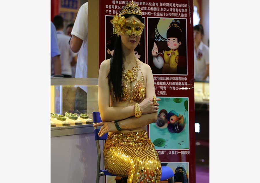 Model in golden bikini dazzles at jewelry exhibition