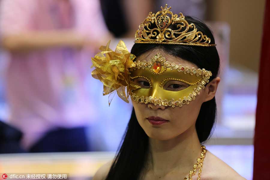 Model in golden bikini dazzles at jewelry exhibition