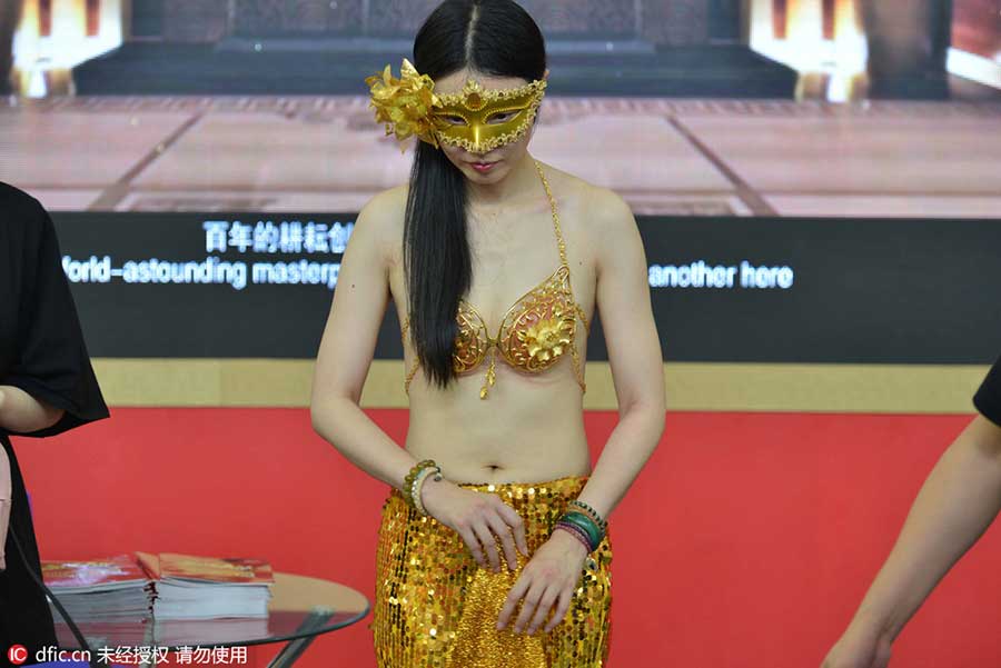 Model in golden bikini dazzles at jewelry exhibition