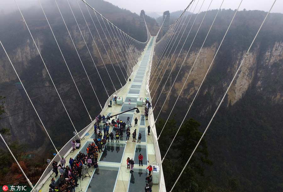 Man braves ice to set new record on world's highest glass bridge