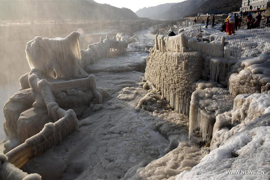 Visitors view frozen Hukou Waterfall on Yellow River