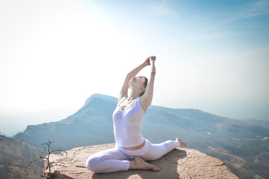 Striking yoga poses on top of cliff