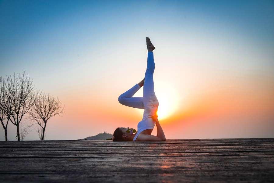 Striking yoga poses on top of cliff