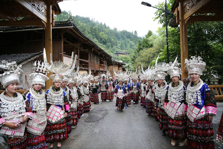 Miao people in traditional costume welcome experts in rural construction