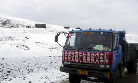 Vehicles heading for quake overturn in snow