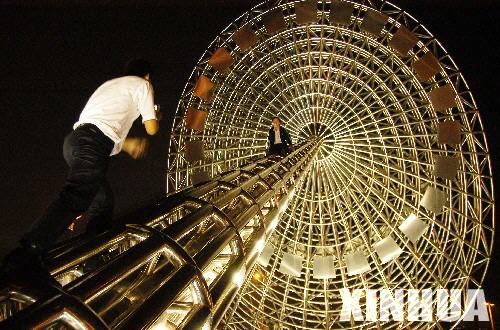 Two men climb on top of a ferris wheel to take photographs