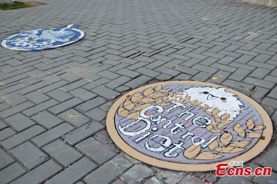 Students paint dream on manhole covers