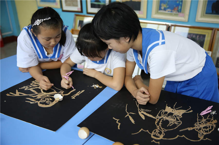 Students make eggshell paintings to remember war heroes